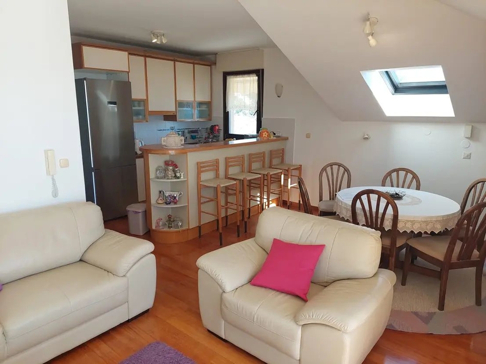 Hangulatos nappali konyhával, bárral és étkezőasztallal egy tetőtéri apartmanban