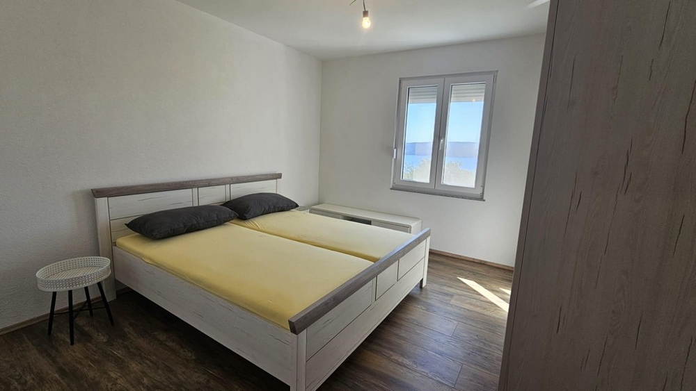 Hálószoba franciaággyal és tengerre néző ablakkal.