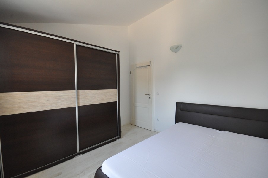 Hálószoba sötét gardróbbal és nagy ággyal