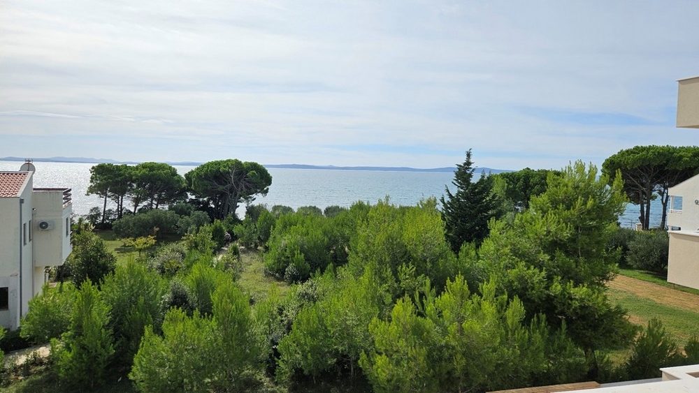 Tengerre néző kilátás a második emeletről zöld növényzettel és fákkal körülvéve