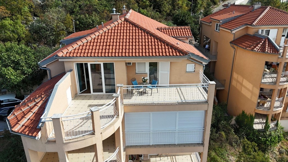 Több erkéllyel és piros cseréptetővel rendelkező épület külső képe