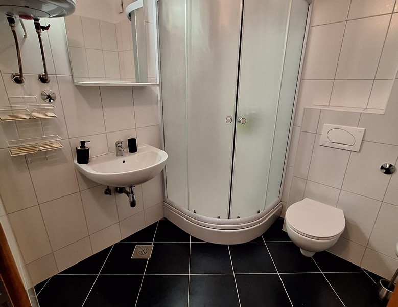 Modern fürdőszoba zuhanykabinnal, mosdóval és WC-vel