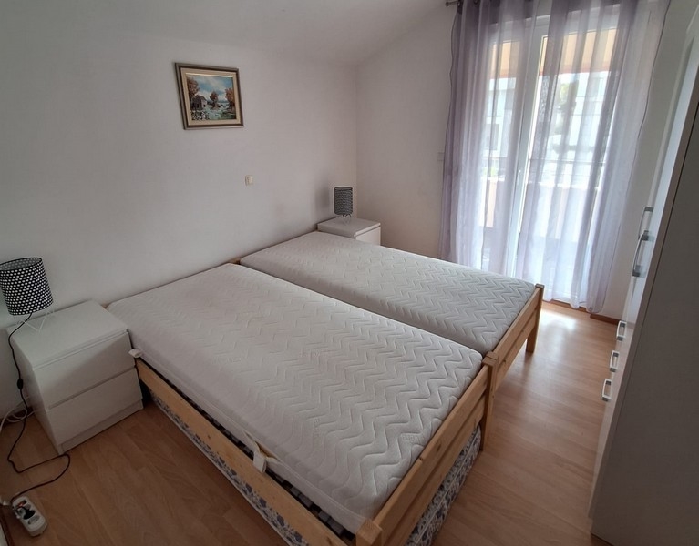 Hálószoba egyszemélyes ággyal és kijárattal az erkélyre