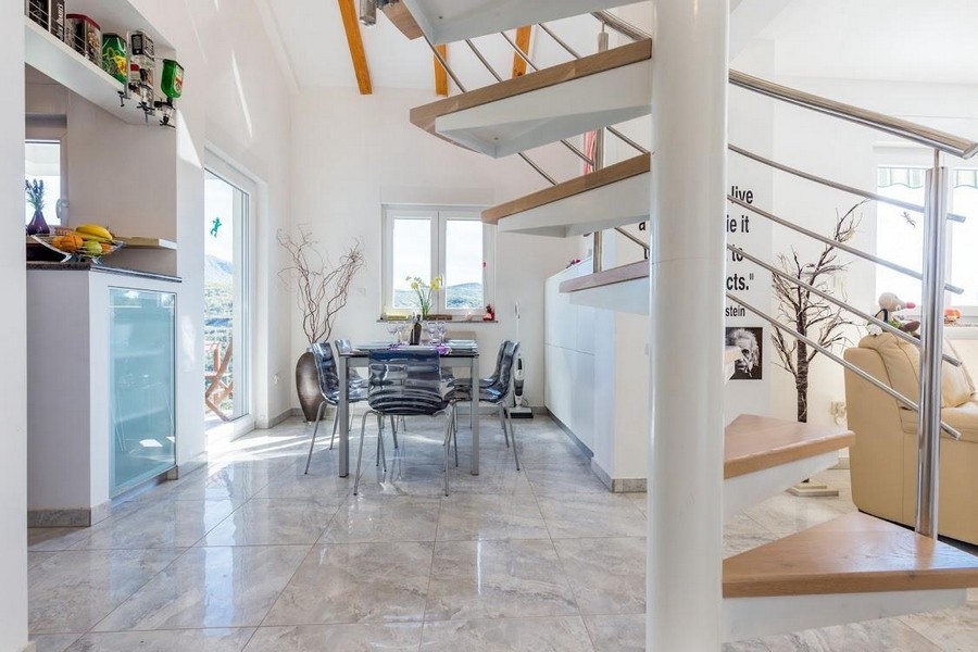 Étkező üvegasztallal és székekkel, a háttérben lépcsőkkel