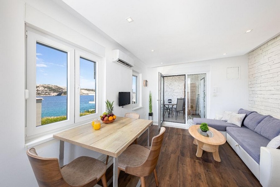 Tengerre néző nappali étkezőasztallal és kanapéval