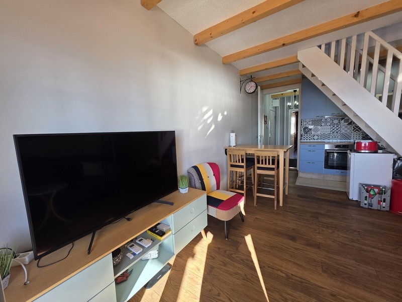 Nappali TV-vel, étkezőasztallal és nyitott konyhával