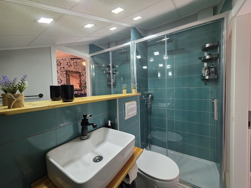 Modern fürdőszoba zuhanyzóval és mosdóval