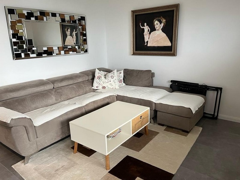 Nappali sarokkanapéval és stílusos fali dekorációval