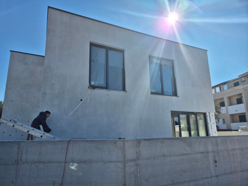 A ház külső nézete nagy ablakokkal és napsütéssel