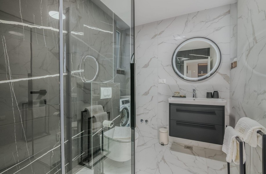Fürdőszoba modern üvegzuhannyal és márványcsempével