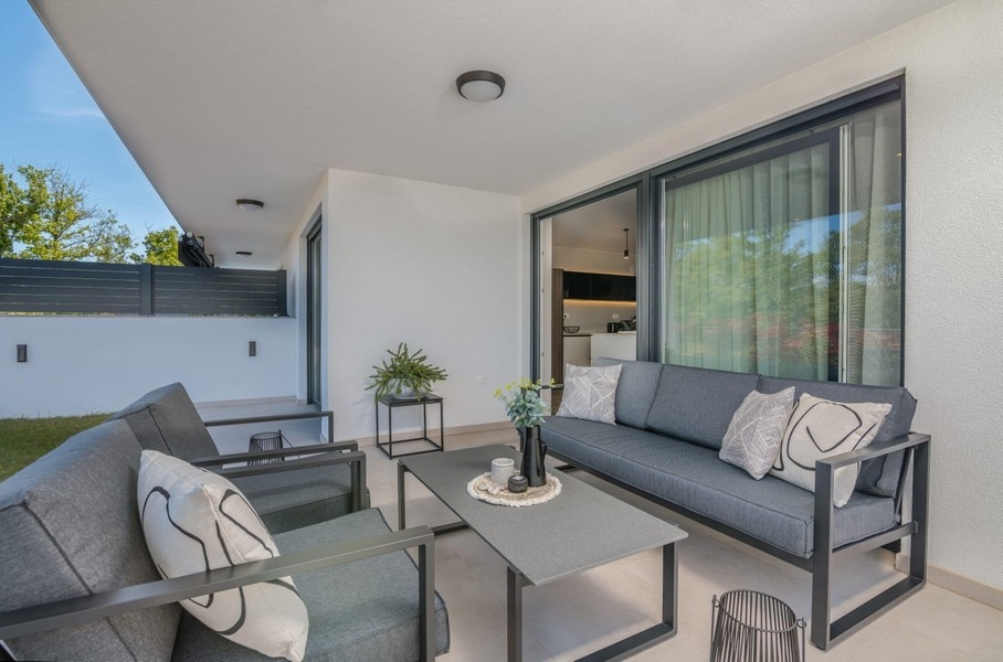 Fedett terasz modern ülőhellyel és kertre néző kilátással