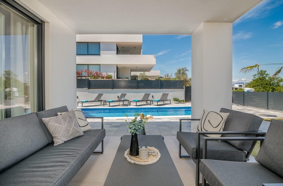 Terasz medencére néző kilátással és napozóágyakkal