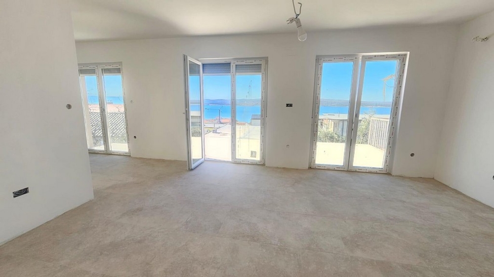 Az A3604-es apartman világos nappalija gyönyörű kilátással a tengerre.