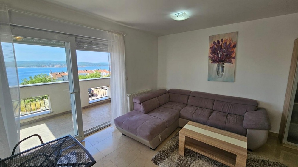 Bútorozott nappali, kilátással a tengerre.