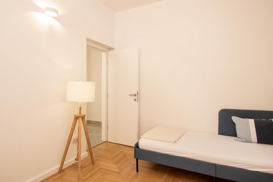 Második hálószoba állólámpával és fapadlóval