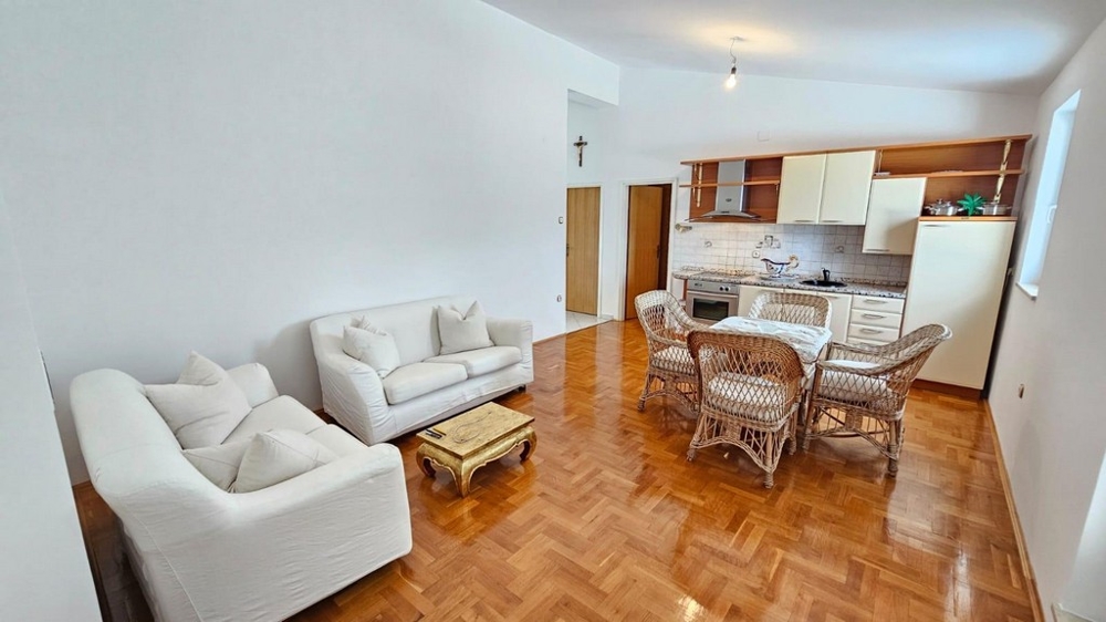 Nappali kanapéval, rattan székekkel és konyhával