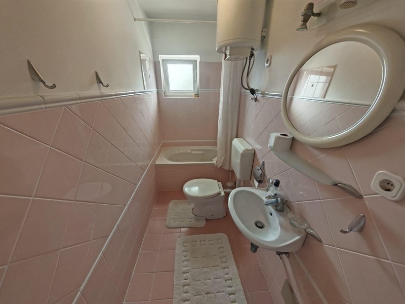 Fürdőszoba káddal és rózsaszín csempével