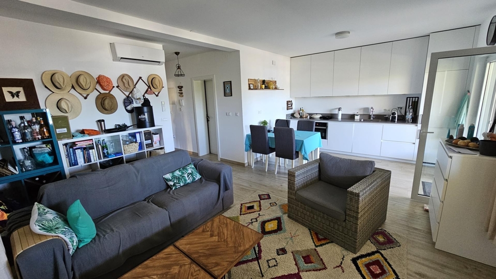 Nappali kanapéval, fotellel és nyitott konyhával