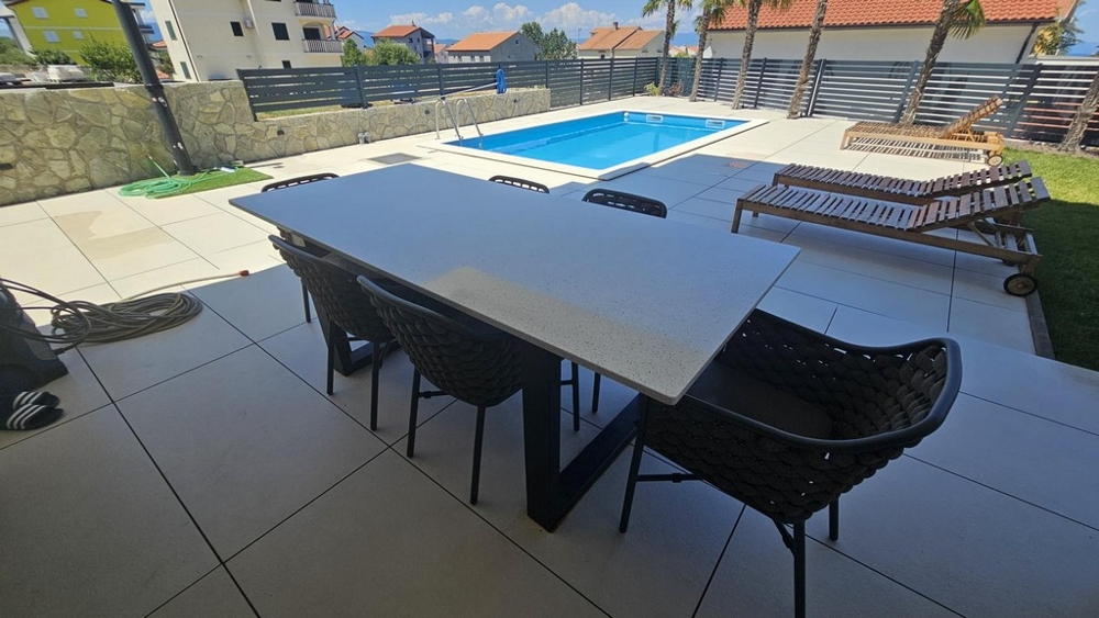 Terasz étkezőasztallal, medencére néző kilátással és napozóágyakkal