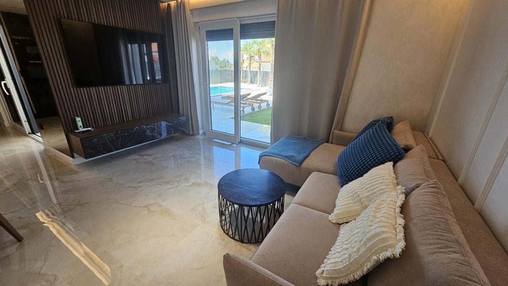 Nappali kanapéval, dohányzóasztallal és kijárattal a teraszra