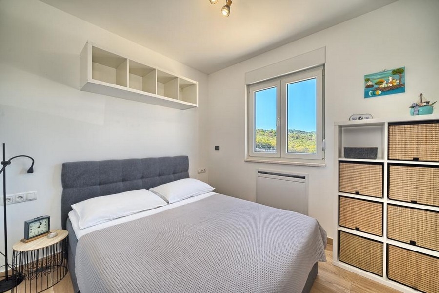 Világos hálószoba franciaággyal és polcokkal