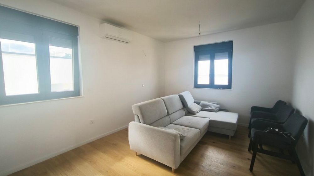 Világos nappali kanapéval és légkondicionálóval