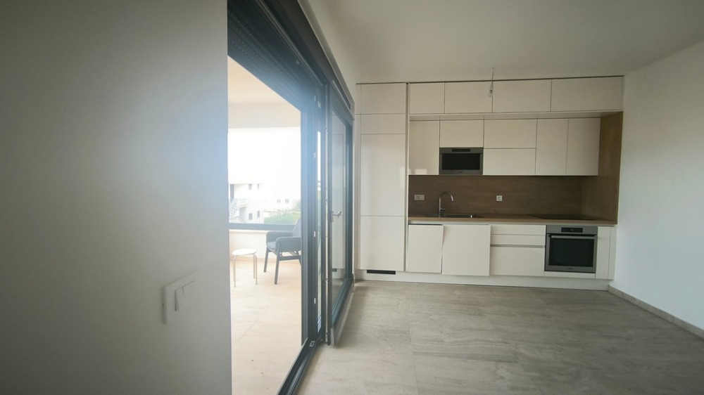 Modern konyha beépített gépekkel, kijárattal a teraszra