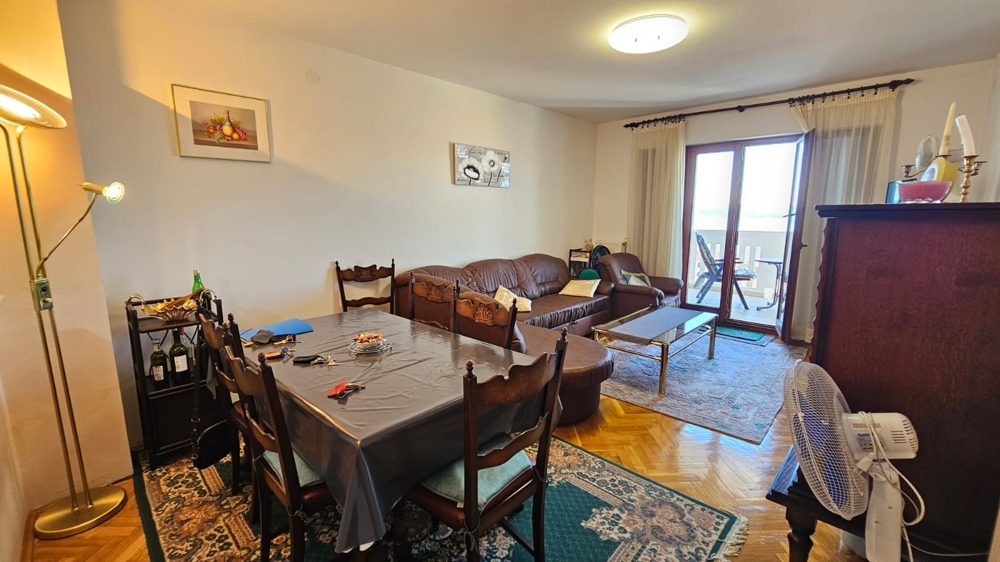 Nappali étkezőasztallal és kijárat az erkélyre