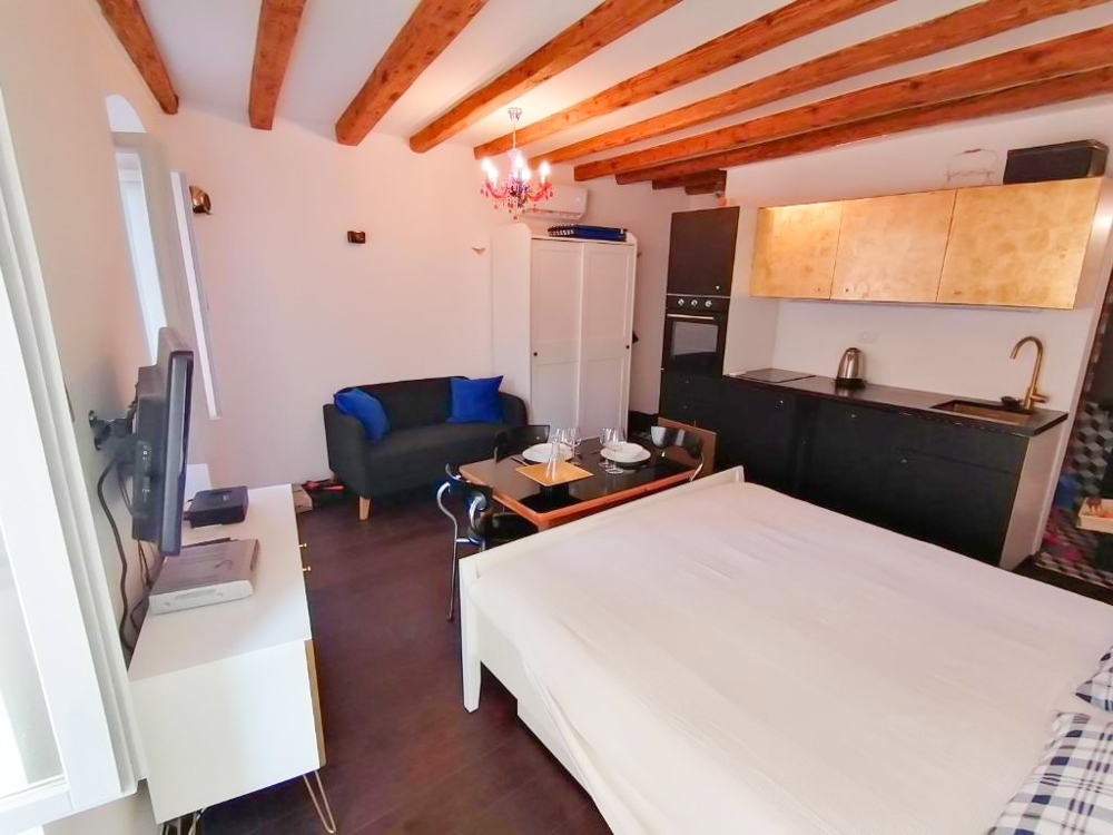 Nappali ággyal és konyhával.