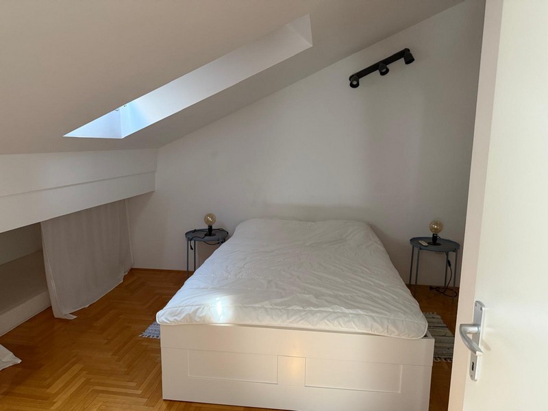 Tetőtéri hálószoba ággyal és tetőablakkal