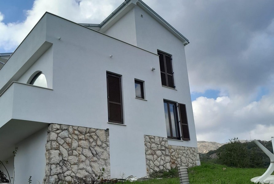 Modern ház kőhomlokzattal és fehér falakkal