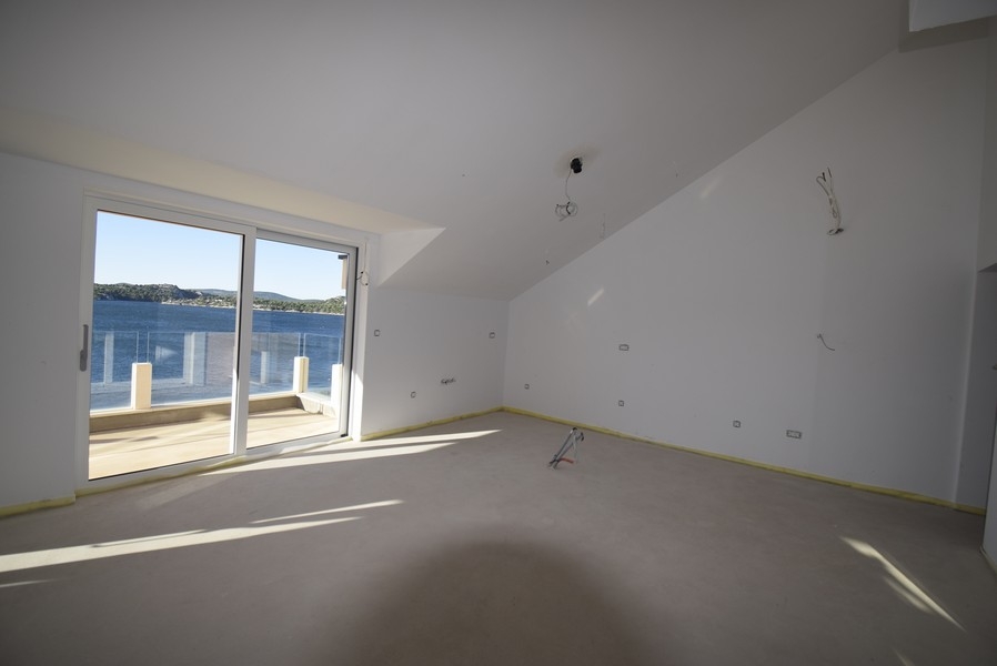 Nappali a tetőtérben, kilátással a teraszra és a tengerre