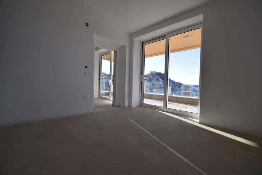 Világos szoba nagy ablakokkal és kijárattal az erkélyre