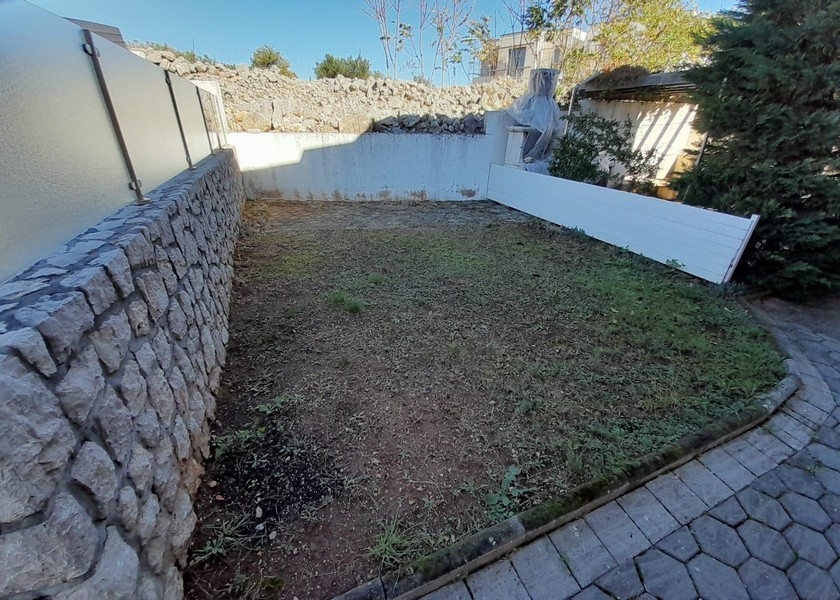 Kis kert kőfallal és pázsittal