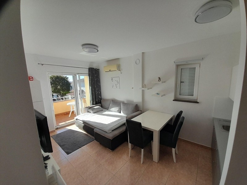 Nappali kanapéval, étkezőasztallal és hozzáféréssel a tengerre néző erkéllyel