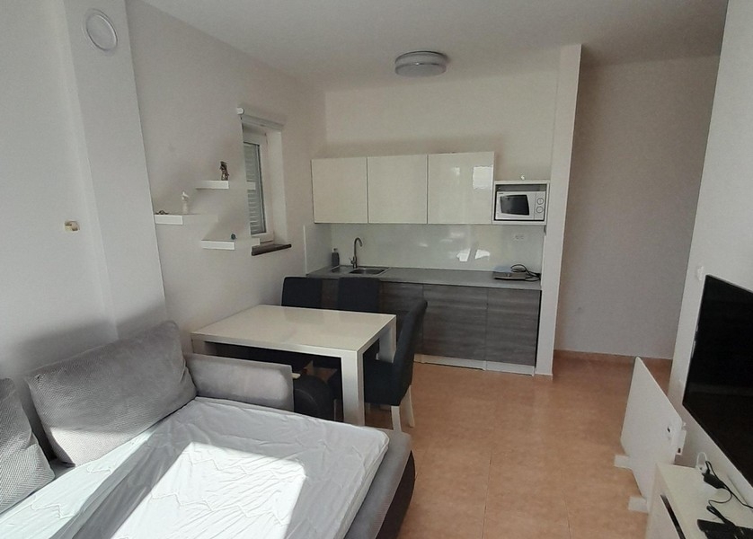 Modern konyhasarok felső és alsó szekrényekkel és étkezővel