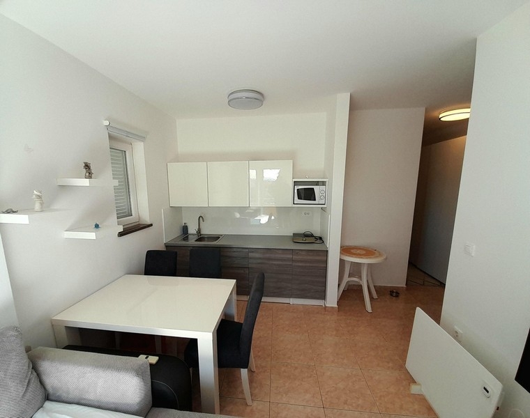 Világos nappali és konyha járólapozott padlóval és kijárattal a folyosóra