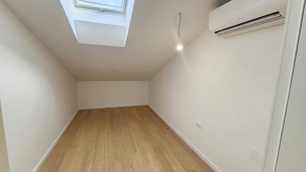 Szoba ferde mennyezettel és tetőablakkal