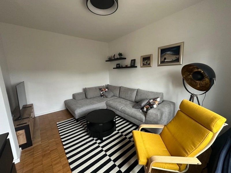 Nappali szürke sarokkanapéval és sárga fotellel