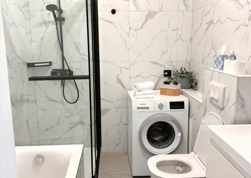 Modern fürdőszoba zuhanyzóval és mosógéppel