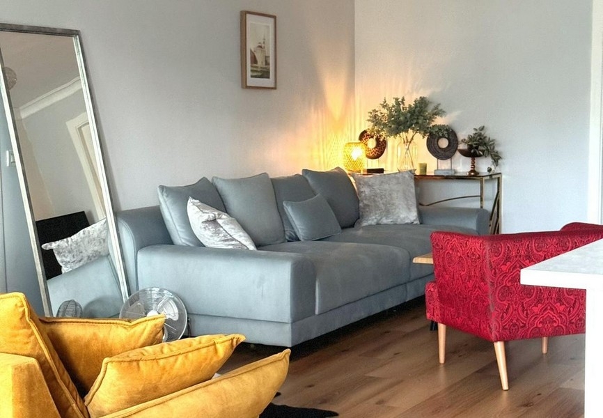 Ülősarok nagy tükörrel és szürke kanapéval