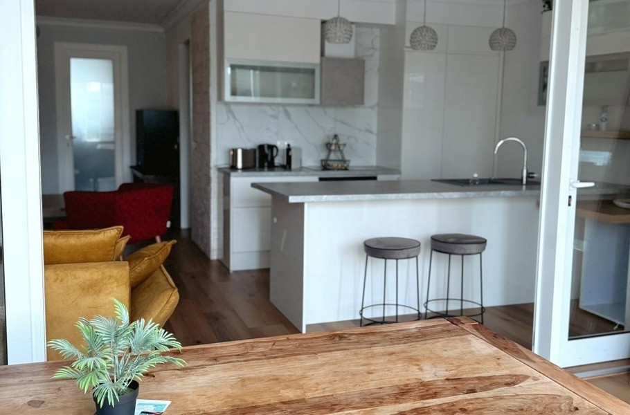 Fából készült asztal és kilátás a fehér konyhára