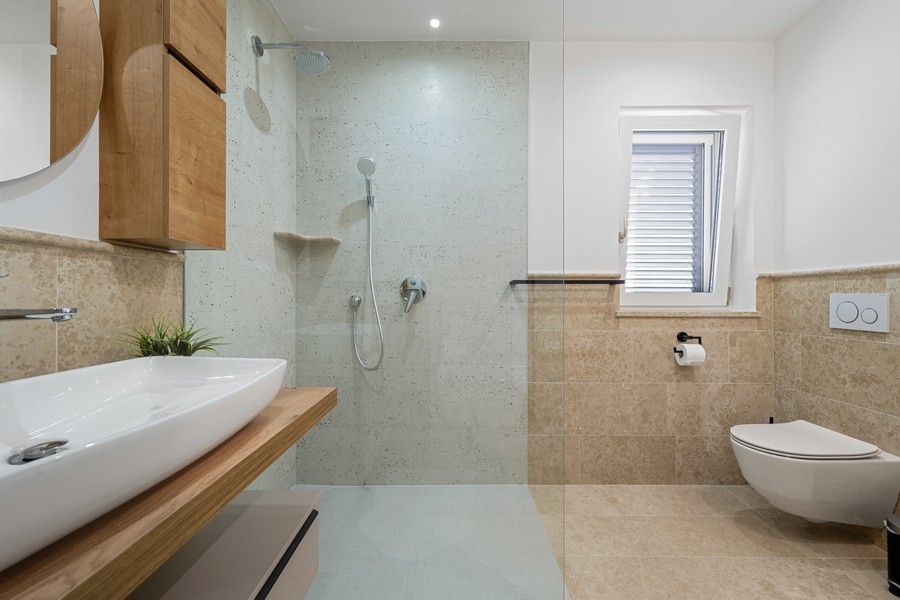 Modern fürdőszoba padlószinti zuhanyzóval és WC-vel