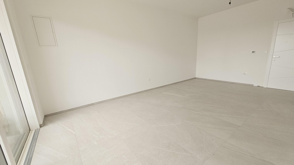 Hálószoba világos falakkal és járólapozott padlóval