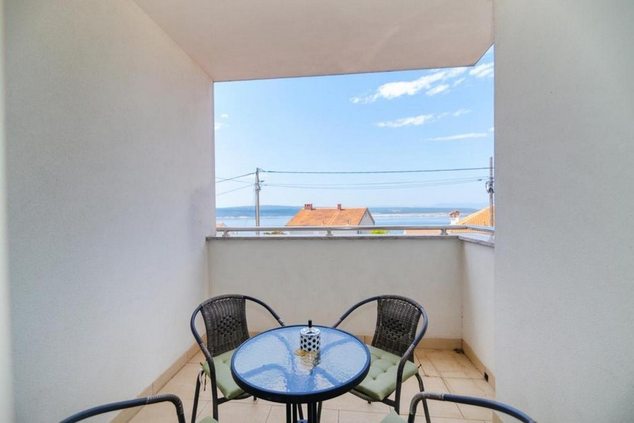 Erkély ülőgarnitúrával és kilátással a tengerre