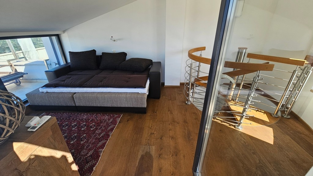 Galéria kanapéval és csigalépcsővel az alsó szintre