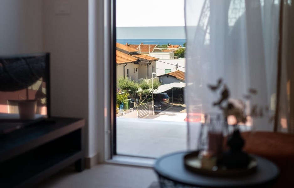 Kilátás a nappaliból a tengerre és a szomszédos házakra