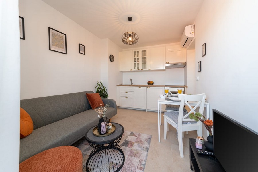 Nappali kanapéval, asztallal és nyitott konyhával