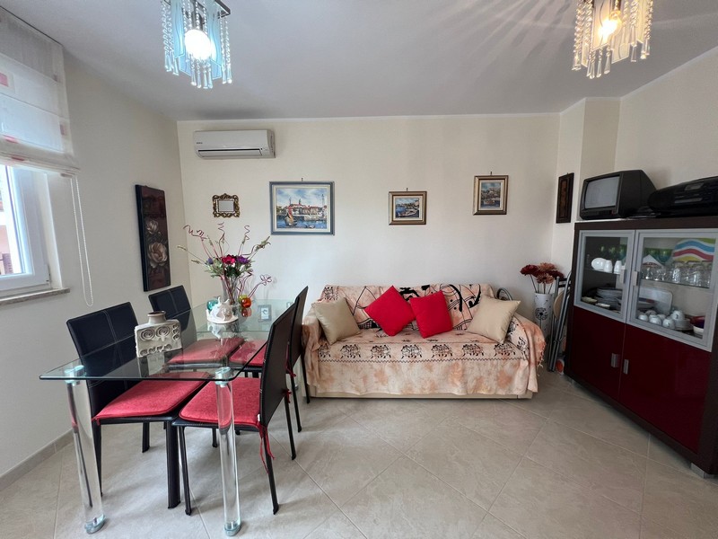 Nappali kanapéval és üveg étkezőasztallal