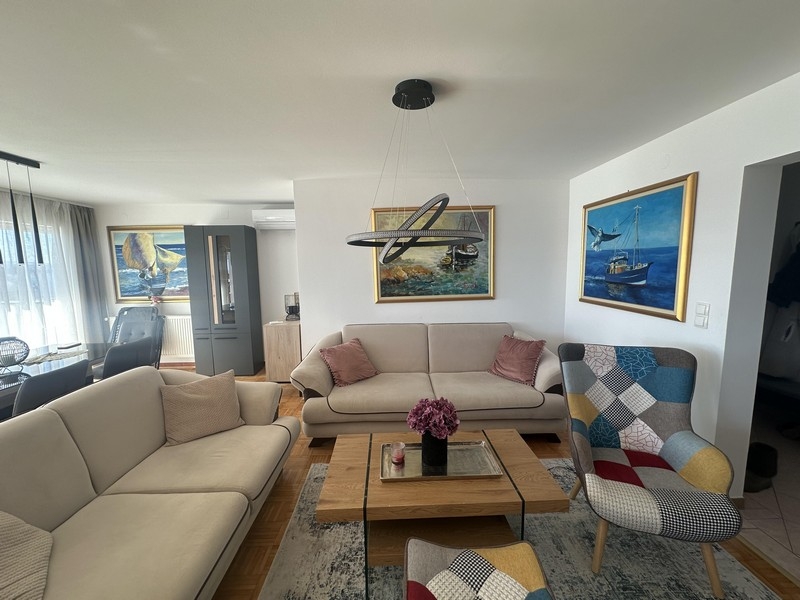 Világos nappali kanapéval, dohányzóasztallal és fali képekkel